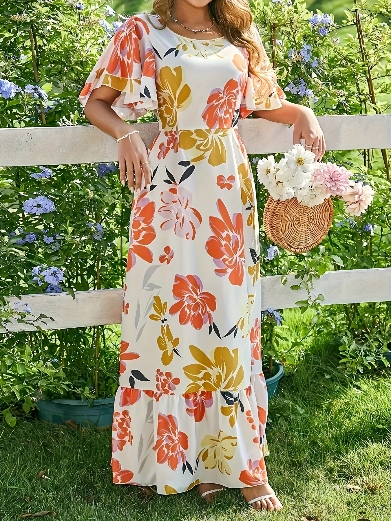 Lange jurk met grote bloemen in warme oranje en gouden tinten