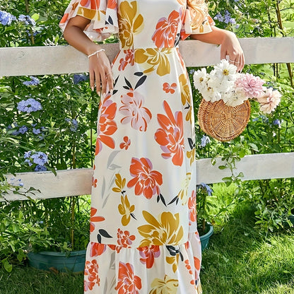 Lange jurk met grote bloemen in warme oranje en gouden tinten
